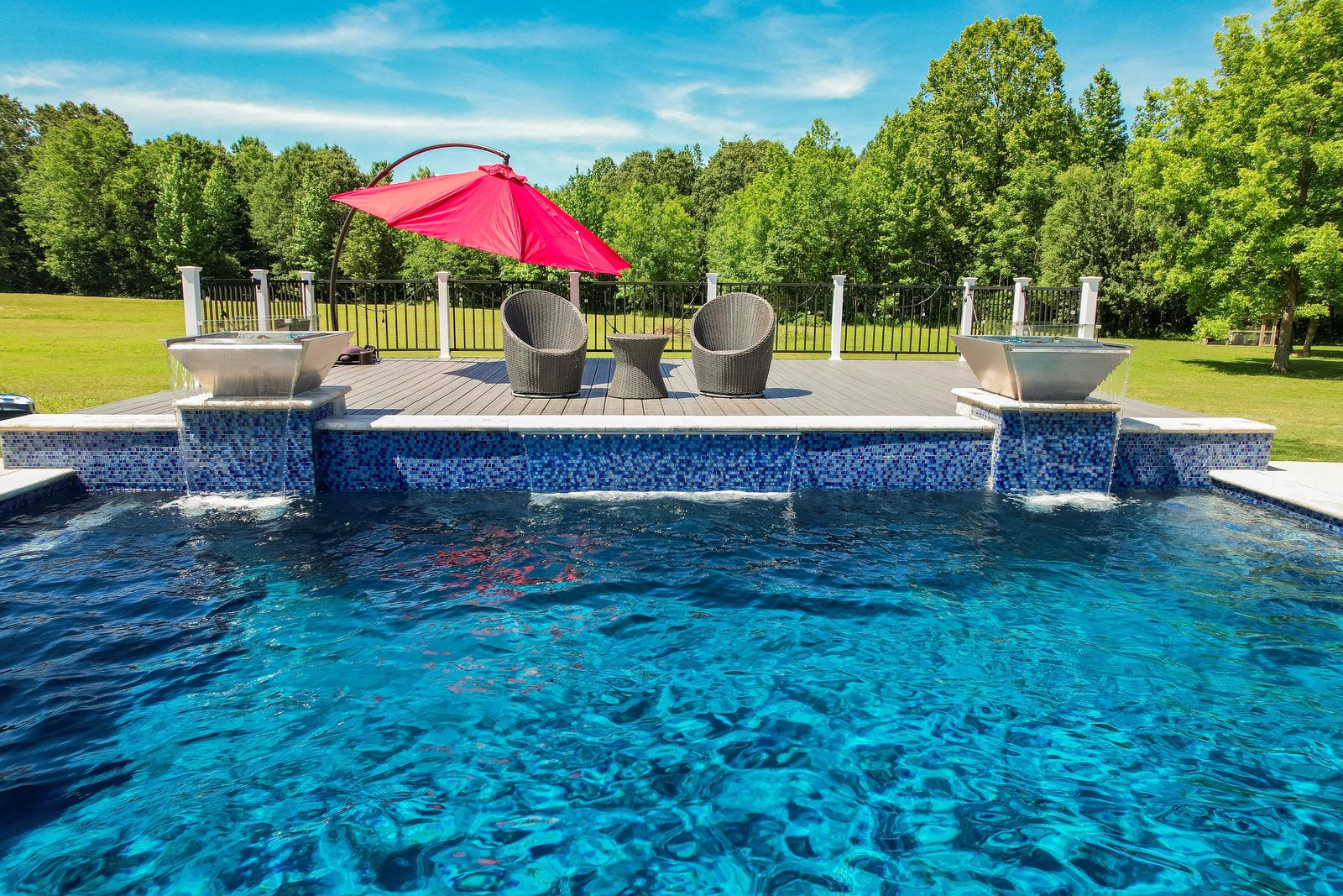 Custom pool with fire bowls at dusk — pool builder website design built to convert
